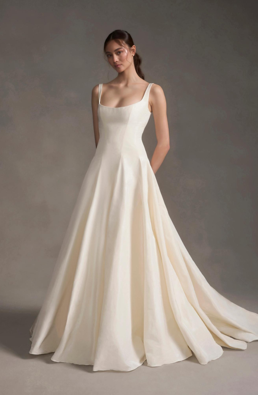 Model is wearing a silk taffeta A-line gown with a structured bodice, drop waist, and internal support for a flattering silhouette.