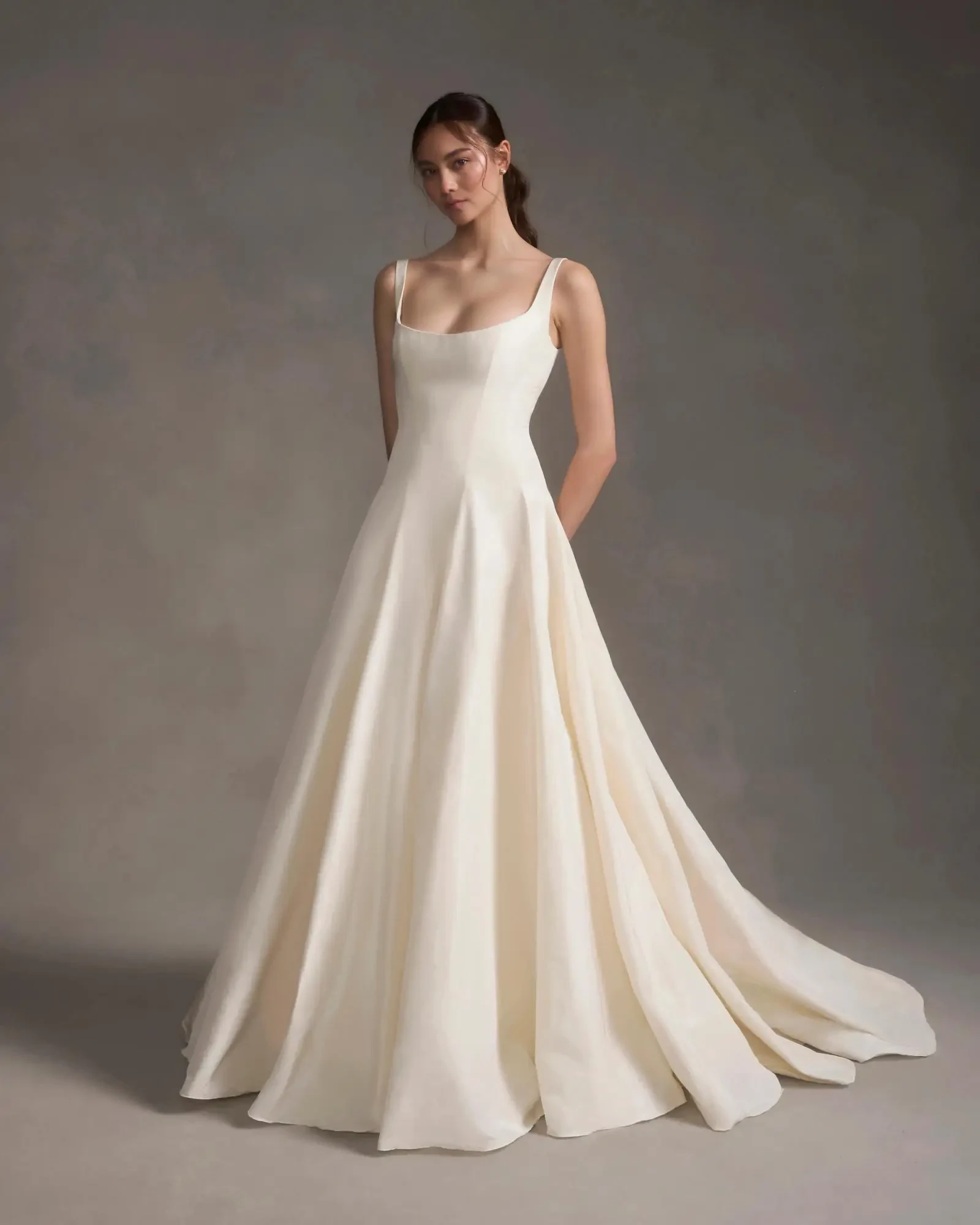 Model is wearing a structured drop-waist gown with an A-line silhouette and silk taffeta fabric