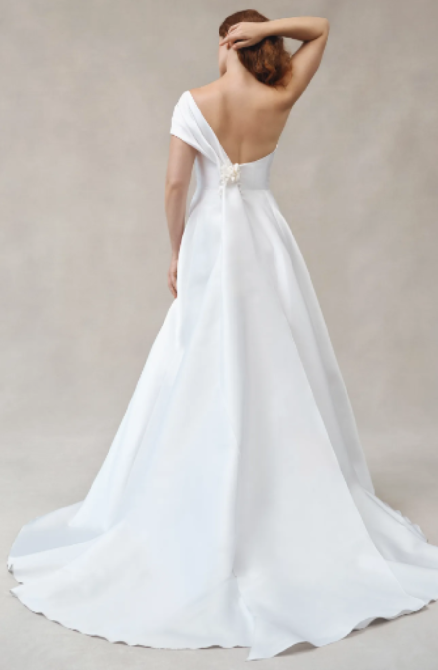Model is wearing a silk blend mikado wedding dress with a sweetheart neckline and hand draped details